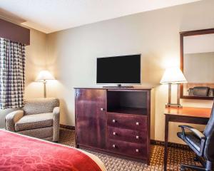 a hotel room with a bed and a flat screen tv at Avon Hotel - Toms River in Toms River