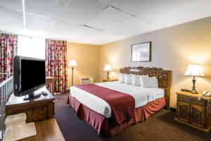 a hotel room with a bed and a flat screen tv at Quality Inn in Taos