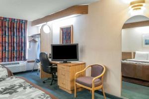 a hotel room with a tv and a desk with a bed at Sleep Inn University in Las Cruces