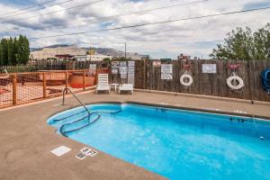 a swimming pool in front of a wooden fence at Quality Inn & Suites Near White Sands National Park in Alamogordo