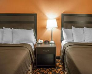 a hotel room with two beds and a lamp on a night stand at Econo Lodge Inn & Suites Santa Fe in Santa Fe