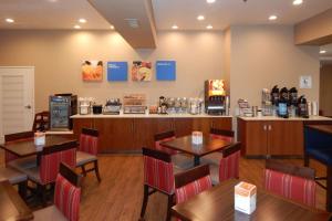 a restaurant with tables and chairs and a counter at Comfort Inn & Suites Las Cruces Mesilla in Las Cruces