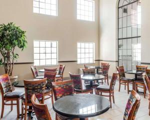 Habitación con mesas, sillas y ventanas. en Quality Inn & Suites, en Albuquerque