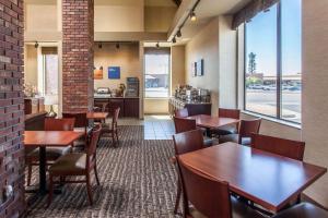 a restaurant with wooden tables and chairs and a kitchen at Comfort Inn & Suites Near Fallon Naval Air Station in Fallon