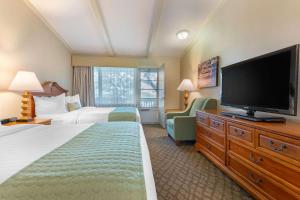 a hotel room with two beds and a flat screen tv at The Inn at Gran View Ogdensburg, Ascend Hotel Collection in Ogdensburg