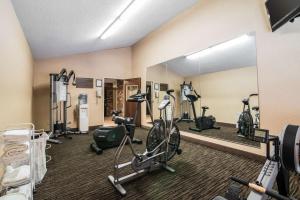 uma sala de fitness com bicicletas ergométricas e um espelho em Clarion Inn & Suites - University Area em Cortland
