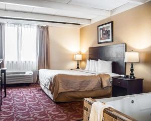 a hotel room with a bed and a bath tub at Quality Inn Buffalo Airport in Cheektowaga +23 photos