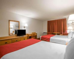 a hotel room with two beds and a television at Rodeway Inn Lake Placid in Lake Placid