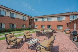 un patio avec des chaises et des tables ainsi qu'un bâtiment dans l'établissement Quality Inn, à Corning