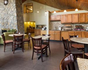 cocina y comedor con mesas y sillas en Comfort Inn & Suites Syracuse-Carrier Circle, en East Syracuse