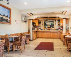 a restaurant with wooden tables and chairs and a kitchen at Econo Lodge at the Falls North in Niagara Falls