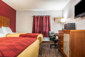 a hotel room with two beds and a flat screen tv at Econo Lodge in Brockport