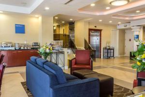 a lobby with two blue chairs and a kitchen at Comfort Inn & Suites LaGuardia Airport in Queens