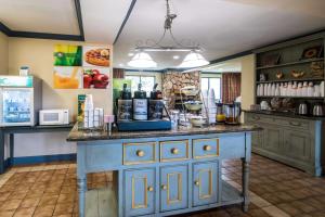 een keuken met een blauw eiland in een kamer bij Quality Inn University Area in Cortland