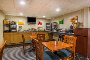 a dining room with tables and chairs and a kitchen at Quality Inn Hyde Park Poughkeepsie North in Hyde Park