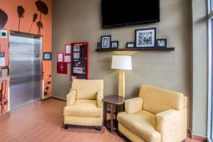 a room with two chairs and a table and a tv at Sleep Inn JFK Airport Rockaway Blvd in Queens