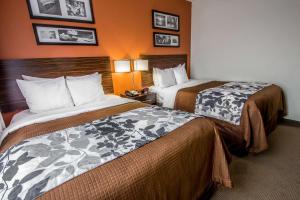 Sleep Inn JFK Airport Rockaway Blvd في كوينز: غرفة فندقية بسريرين وصور على الحائط