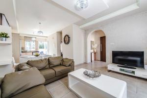 a large living room with a couch and a tv at Timotheos Villa in Protaras