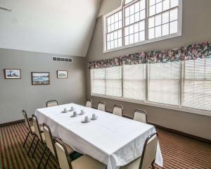 a conference room with a table and chairs and two windows at Rodeway Inn in Lakeville