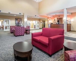 a living room with a red couch and tables at University Inn Vestal in Vestal