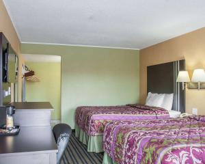 a hotel room with two beds and a desk at Amherst Inn & Suites in Amherst