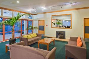 a living room with couches and a fireplace at Comfort Hotel Flames Whangarei in Whangarei