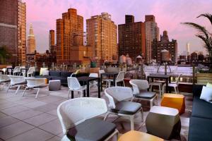 
a row of tables with chairs and umbrellas in a city at Cambria Hotel New York - Chelsea in New York
