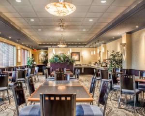 un restaurante con mesas y sillas en una habitación en Clarion Hotel & Suites Riverfront Oswego, en Oswego