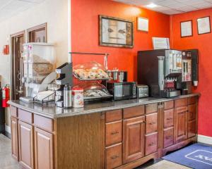 a kitchen with orange walls and a counter with food at Rodeway Inn Huntington Station - Melville in Huntington