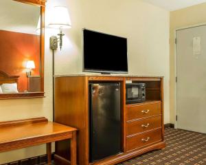 a hotel room with a flat screen tv on top of a refrigerator at Rodeway Inn in Montpelier