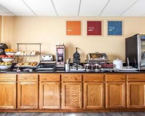una cocina con armarios de madera y una barra con comida en Quality Inn Seaman, en Seaman