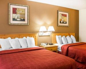 Habitación de hotel con 2 camas con sábanas rojas en Quality Inn, en Elyria