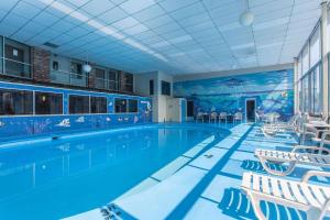 a large swimming pool with white chairs and a swimming pool at Rodeway Inn Sandusky North in Sandusky +3 photos