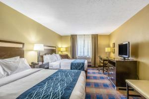 a hotel room with two beds and a flat screen tv at Comfort Inn Independence in Independence