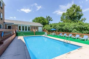 a swimming pool with chairs and a house at Comfort Inn Independence in Independence