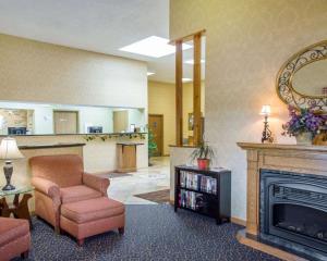 a living room with a fireplace and a chair at Comfort Inn in Piketon