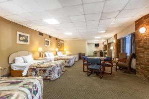 a hotel room with four beds and a table and chairs at Rodeway Inn Sandusky North in Sandusky +30 photos