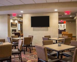 a restaurant with tables and chairs and a flat screen tv at Comfort Inn & Suites in Wadsworth