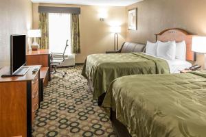 a hotel room with two beds and a television at Quality Inn & Suites Columbus in Columbus