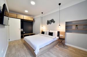 a bedroom with a large white bed and wooden floors at Fishnjak Apartments - Central Zagreb in Zagreb