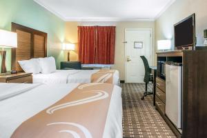 a hotel room with two beds and a desk at Quality Inn in Findlay