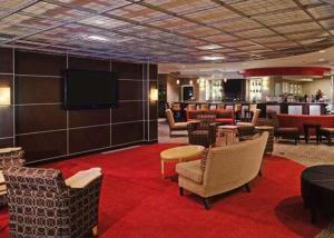 a lobby with chairs and a television and a bar at Cambria Hotel Columbus - Polaris in Columbus
