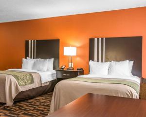 two beds in a hotel room with orange walls at Comfort Inn Maumee - Perrysburg Area in Maumee