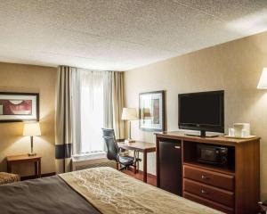 a hotel room with a bed and a flat screen tv at Quality Inn Springboro West in Springboro