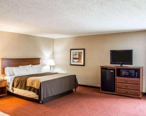 a hotel room with a bed and a flat screen tv at Quality Inn Springboro West in Springboro