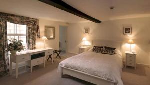 a bedroom with a bed and a desk and a window at Bath Place Hotel in Oxford