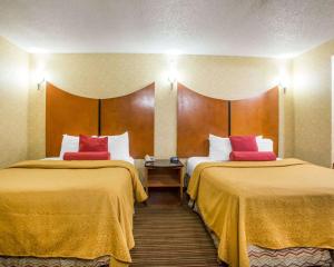 a hotel room with two beds with yellow and red pillows at Quality Inn & Suites North-Polaris in Worthington +24 photos