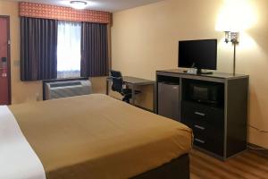 een hotelkamer met een bed en een flatscreen-tv bij Econo Lodge in Purcell