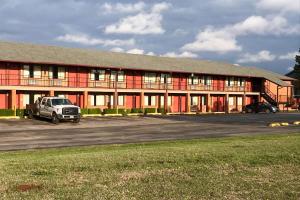 een rood gebouw met een vrachtwagen er voor geparkeerd bij Econo Lodge in Purcell