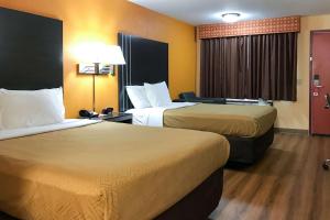 una habitación de hotel con 2 camas y una lámpara en Econo Lodge en Purcell